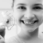 Une jeune fille souriante montrant son appareil dentaire.