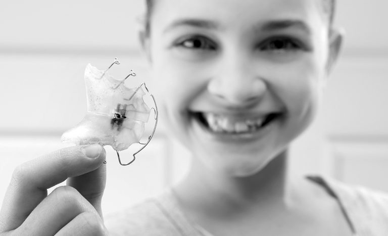 Une jeune fille souriante montrant son appareil dentaire.