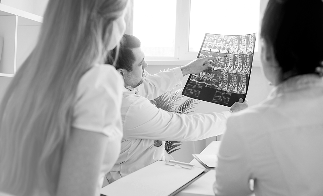 Un formateur en dentisterie montral un détail d'une radiographie dentaire à des dentistes de l'Académie Dentaire Multidisciplinaire.