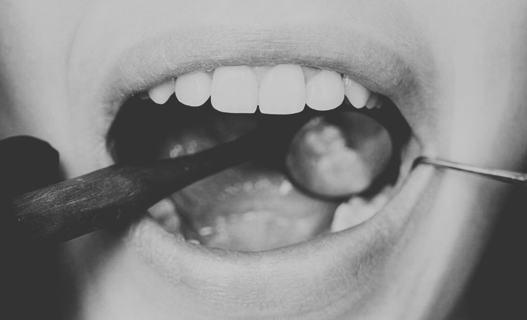 Un dentiste examine les dents d'un patient à l'aide d'instruments.
